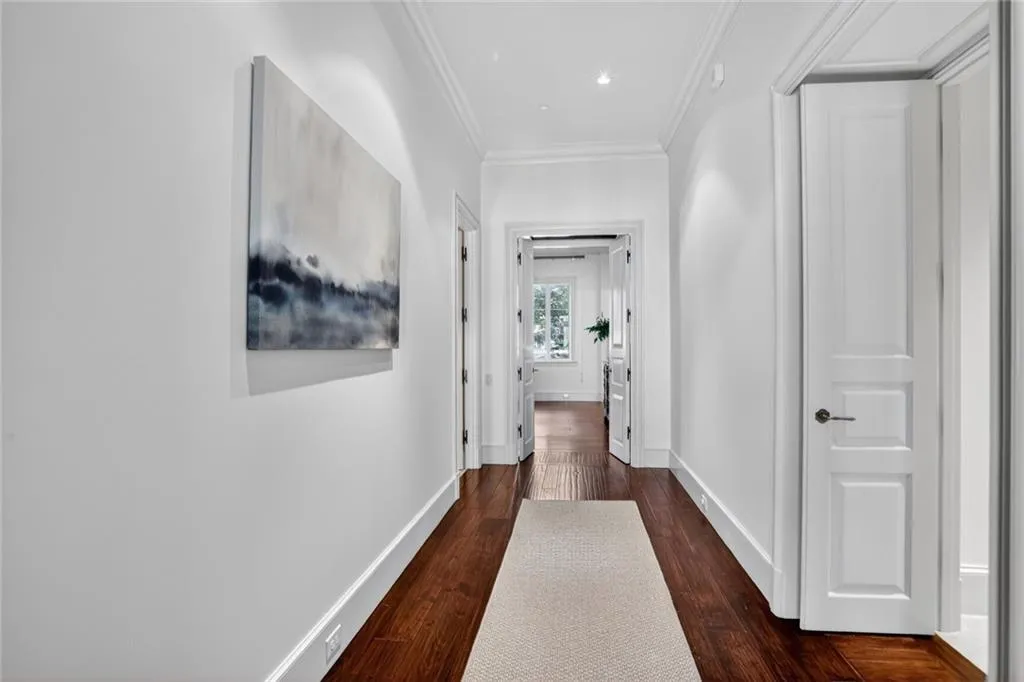 Hallway with dark wood-style floors and ornamental molding