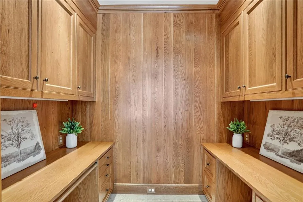 Office featuring built in desk and wooden walls