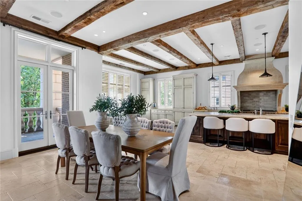 Dining room with beamed ceiling, stone tile floors, french doors, and recessed lighting