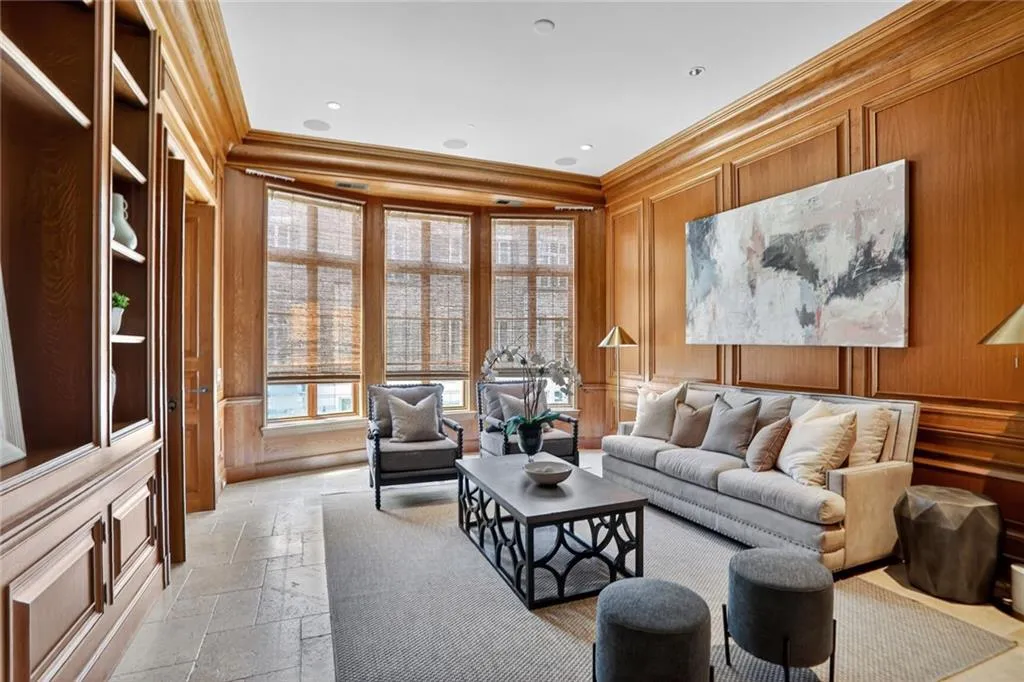 Sitting room featuring a decorative wall, ornamental molding, and stone tile flooring