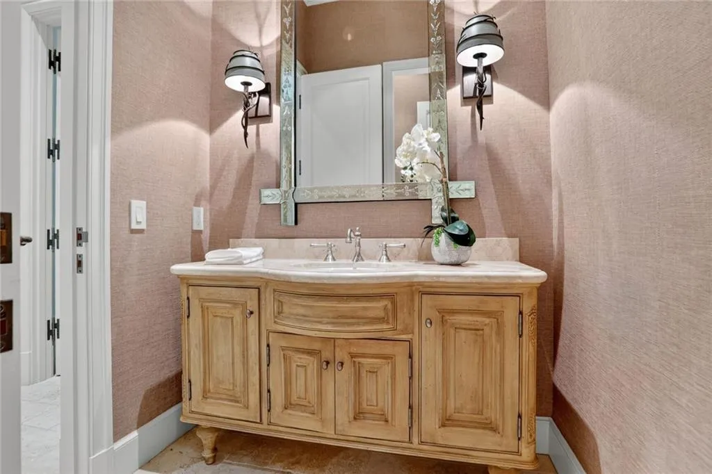 Bathroom featuring vanity, wallpapered walls, and tile patterned flooring