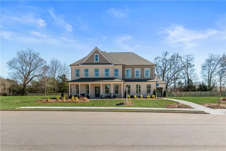 Two-story residence with a covered front porch, a gabled roofline, and a paved driveway