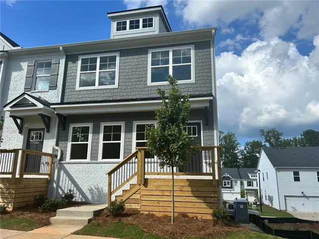 Multi-level exterior with shingle siding, white window trim, and a dormer