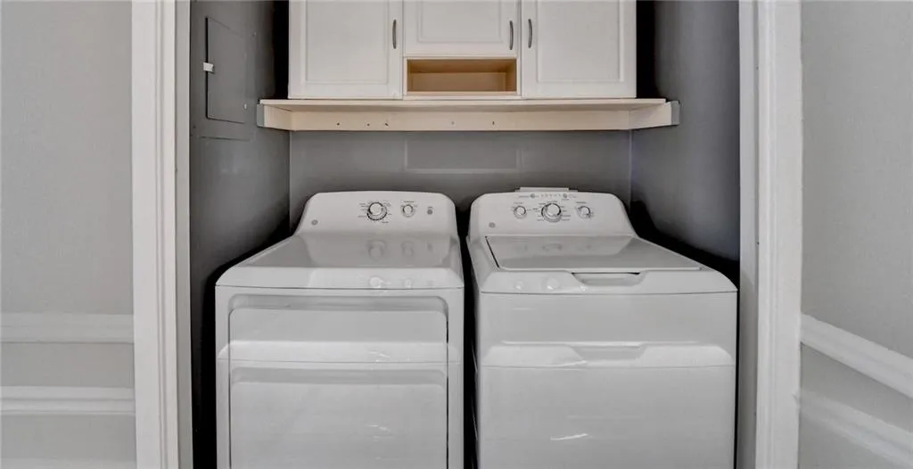 Washroom featuring washing machine and clothes dryer and cabinet space