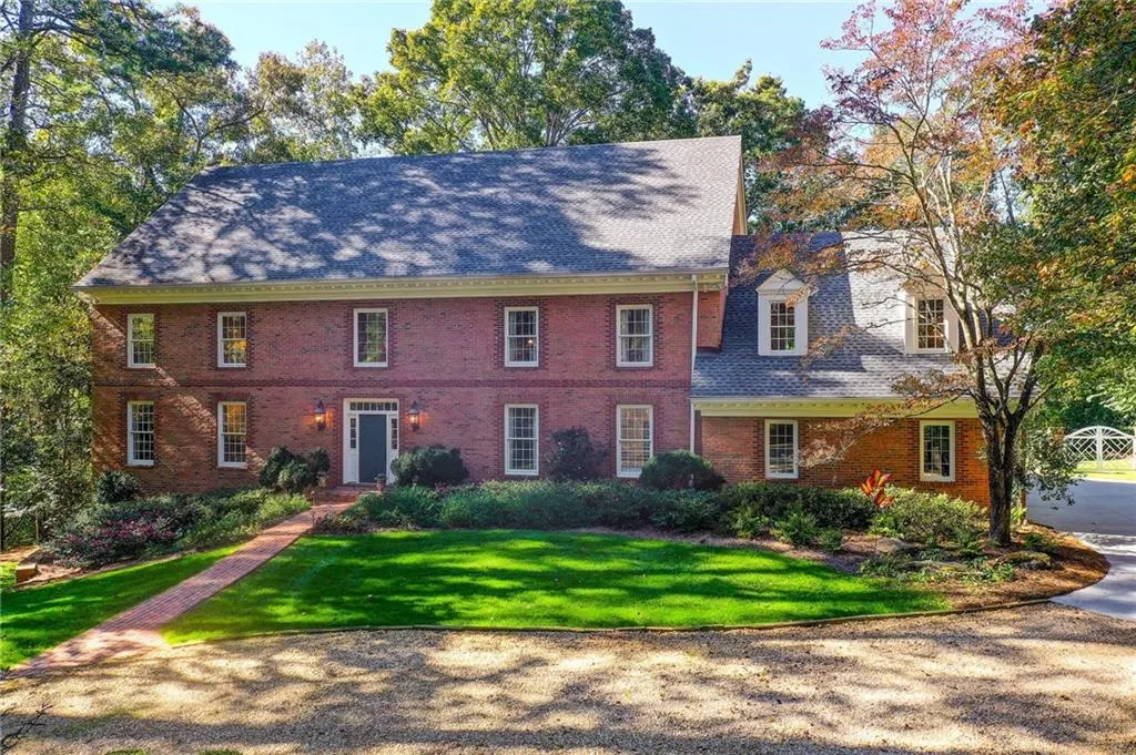 Colonial house featuring brick siding, a front yard, and a shingled roof Colonial house featuring brick siding, a front yard, and a shingled roof
