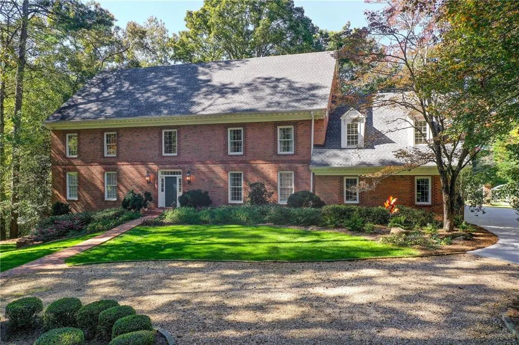 Colonial-style house featuring a front yard, brick siding, and roof with shingles Colonial-style house featuring a front yard, brick siding, and roof with shingles