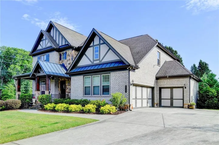 Two-story brick and stone exterior featuring a prominent front porch with a metal roof accent