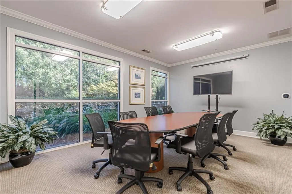 Carpeted office with crown molding and baseboards