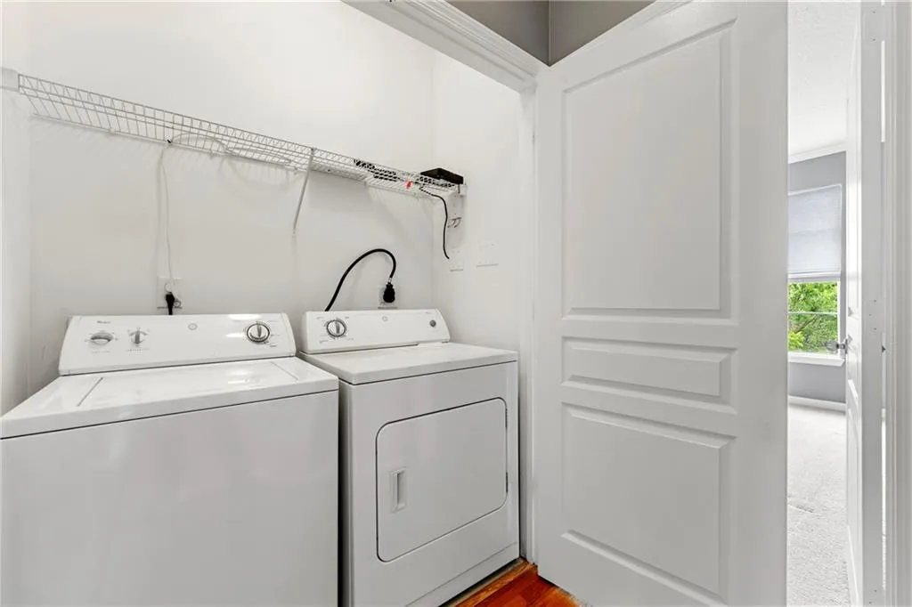 Washroom featuring separate washer and dryer and wood finished floors