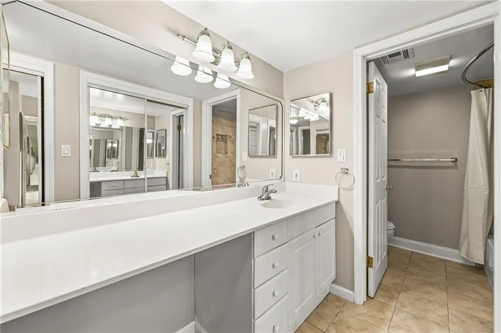 Vanity with white cabinetry, integrated sink, and white countertop