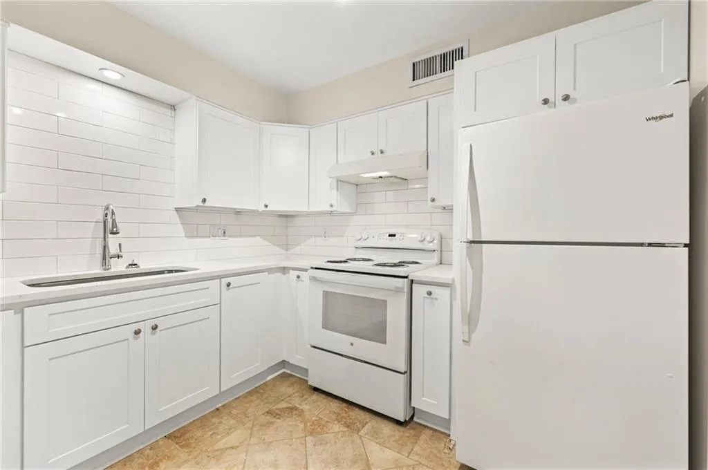 White cabinetry with brushed nickel hardware, full white subway tile backsplash, white  Quartz countertop, stainless steel sink with gooseneck faucet
