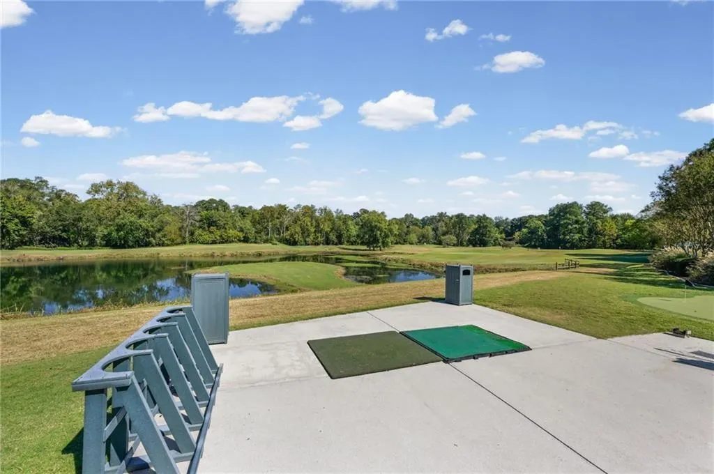 Lush golf course setting featuring water features, mature trees, and putting greens