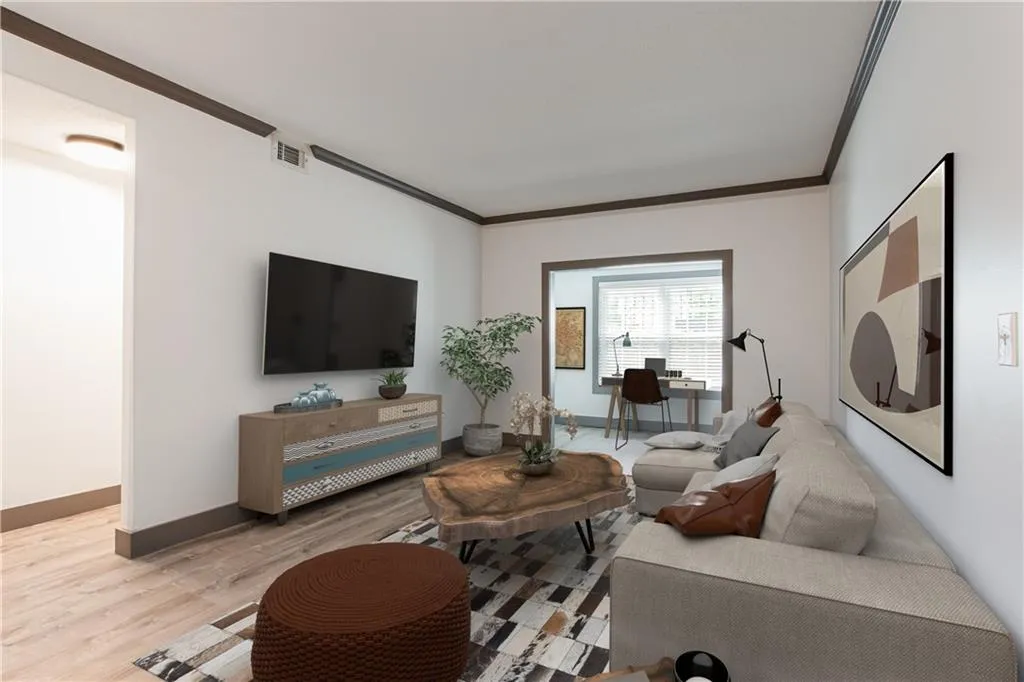 Living room with crown molding and light wood finished floors