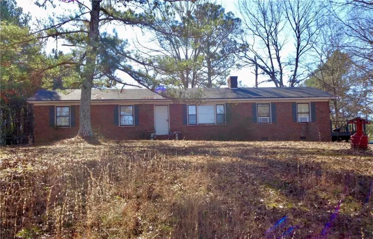 Brick exterior with dark shutters, multiple windows, and a prominent chimney
