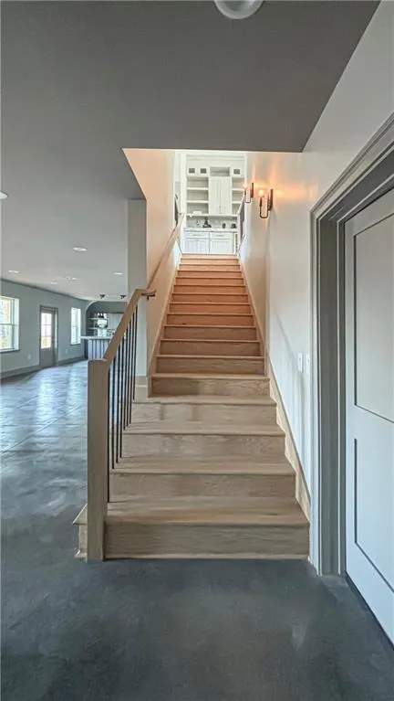 Staircase featuring finished concrete floors