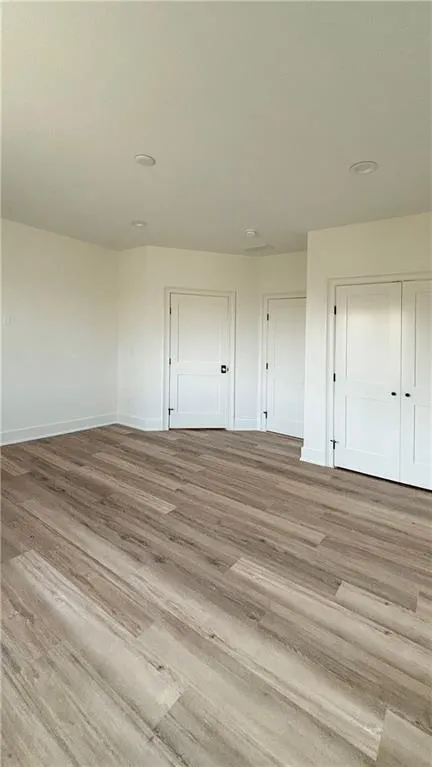 Unfurnished bedroom featuring wood finished floors and a closet