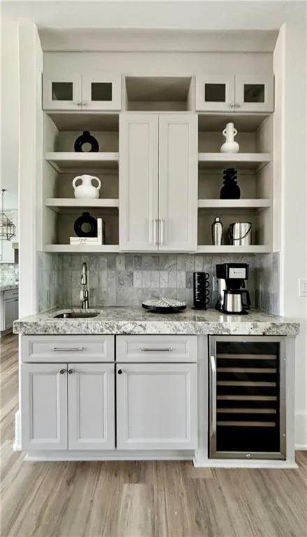 Bar area featuring open shelves and white cabinetry