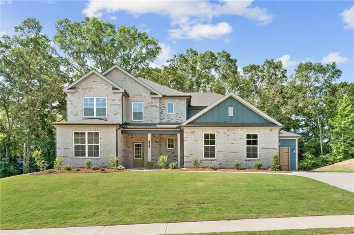 Brick façade with blue accent siding, covered front porch, an attached garage, and a concrete driveway