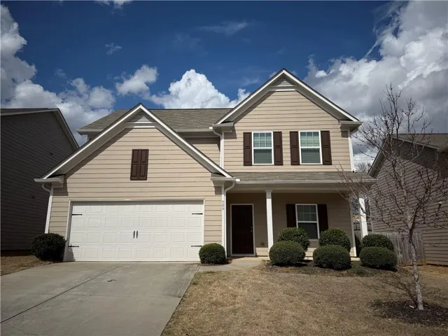 Traditional home featuring a porch, driveway, and a shingled roof