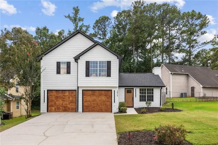 Two-story residence featuring white horizontal siding and black-trimmed windows with shutters