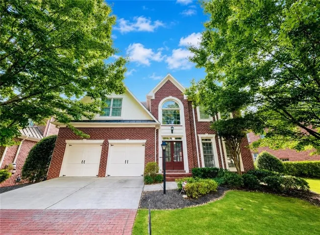 Brick exterior with white trim, featuring a prominent arched window above the entrance