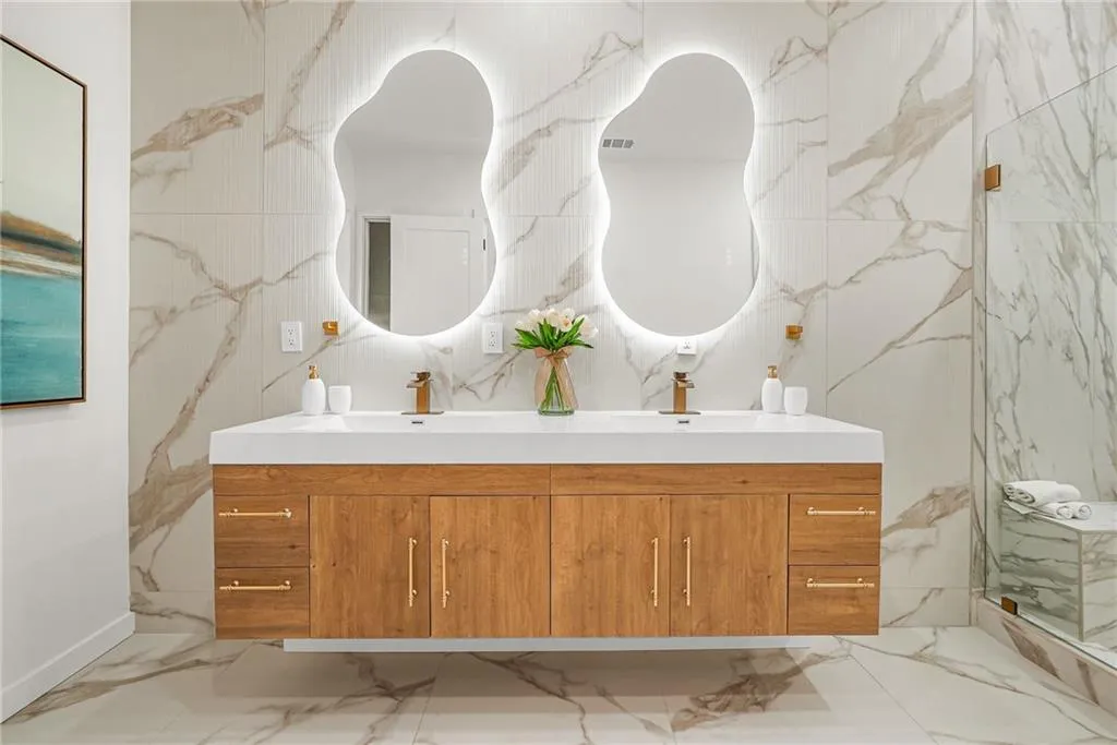 Floating wood-finish vanity with dual integrated sinks and gold-tone hardware
