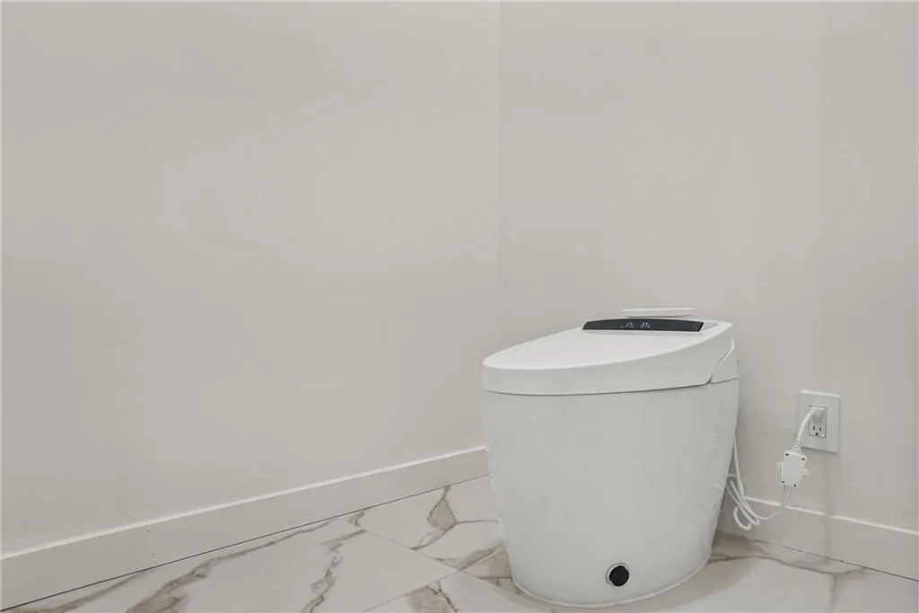 Modern toilet with integrated controls and white tile flooring