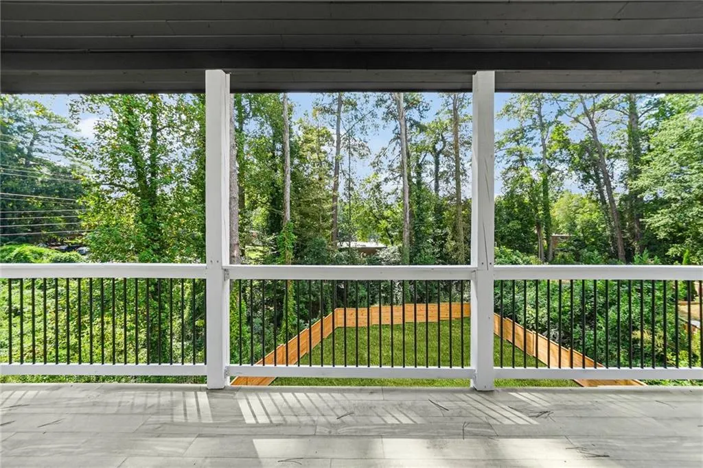 Screened porch with an expansive outdoor space, composite flooring, white railings, and black balusters