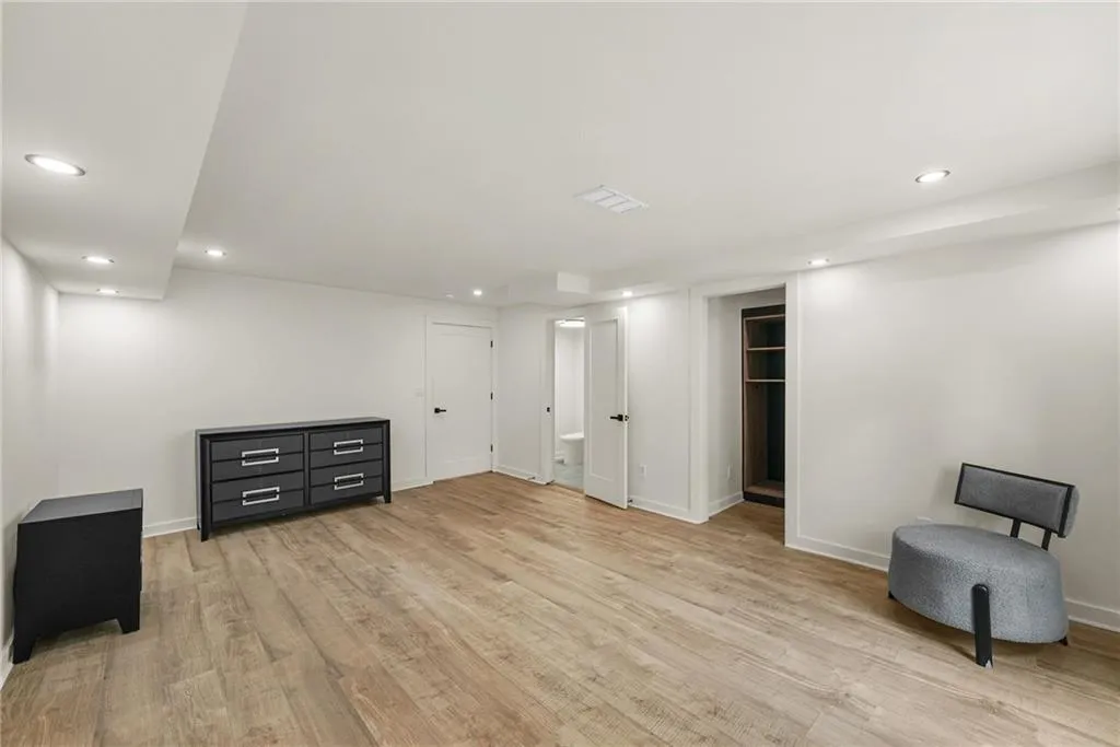 Recessed lighting, wood-finish flooring, white walls, built-in shelving, and white doors