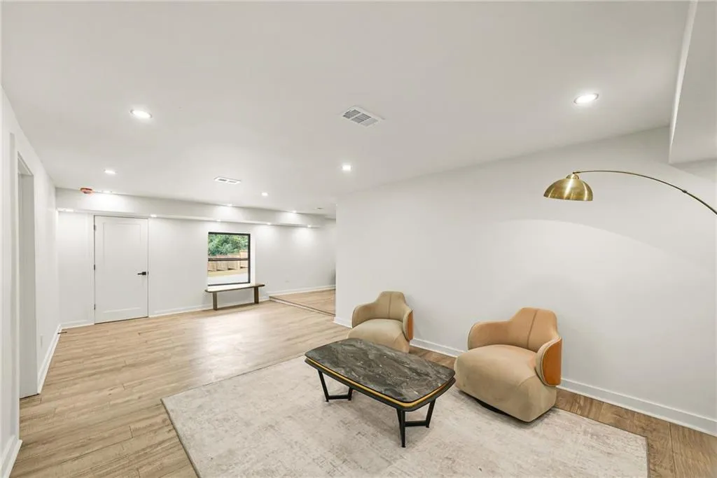 Spacious room with recessed lighting, wood-finish flooring, and a large window