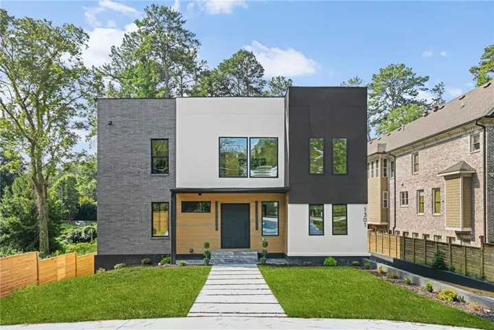 Modern exterior featuring dark gray brick, light-colored stucco, and wood-finish siding