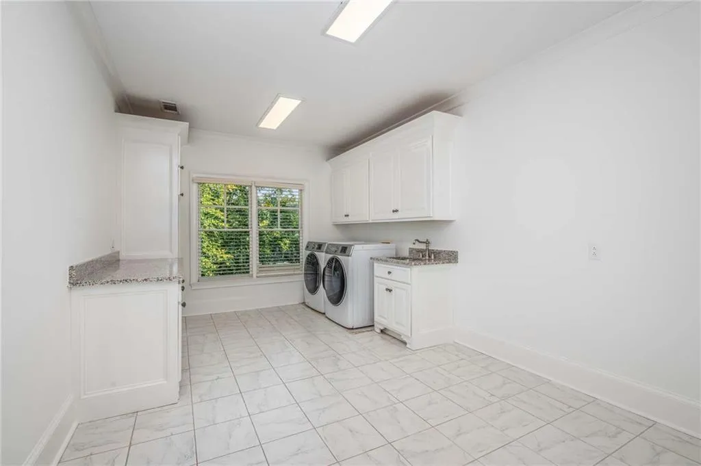 Upstairs laundry with cabinetry and room for a refrigerator