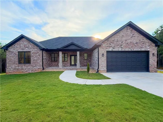 Brick exterior with black trim and a dark asphalt shingle roof