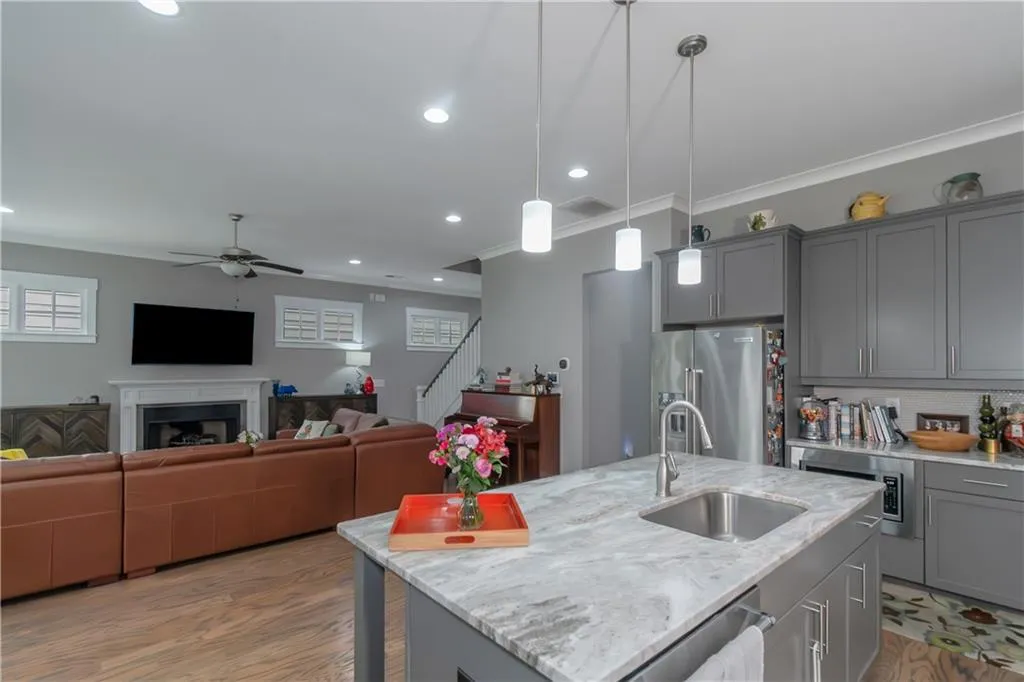 Kitchen featuring a sink, stainless steel appliances, open floor plan, a ceiling fan, and gray cabinetry
