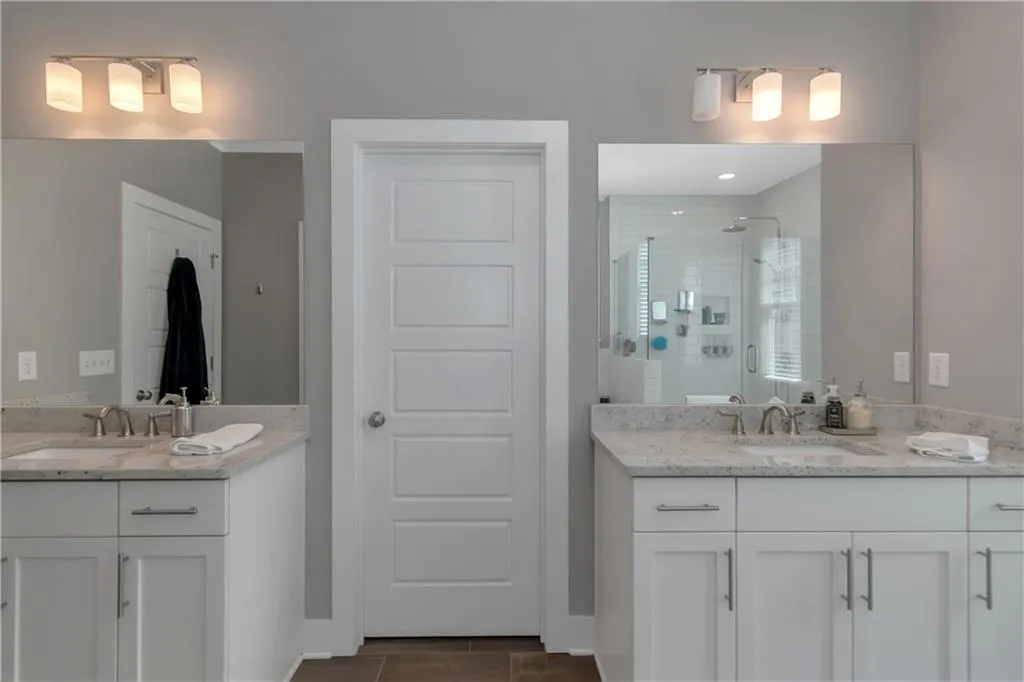 Full bath featuring a sink, two vanities, and a shower stall