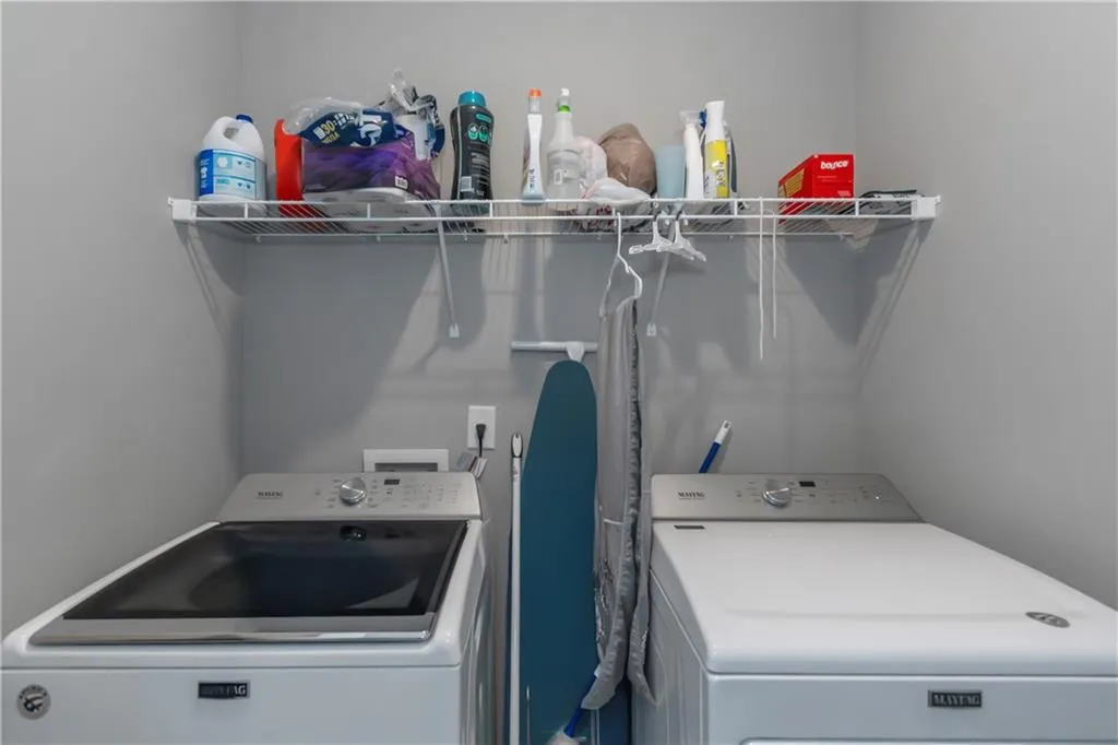 Clothes washing area featuring independent washer and dryer and laundry area
