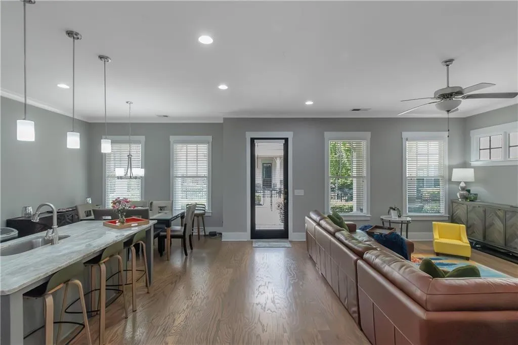 Living area featuring baseboards, ceiling fan with notable chandelier, light wood finished floors, ornamental molding, and recessed lighting