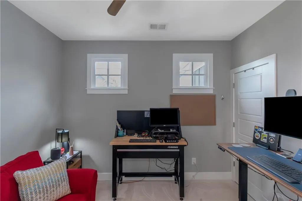 Office space featuring baseboards, ceiling fan, a healthy amount of sunlight, and visible vents