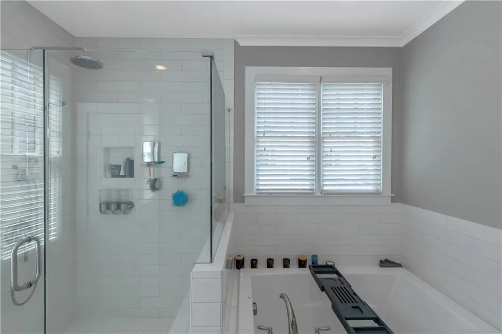 Full bathroom with crown molding, a shower stall, and a bath