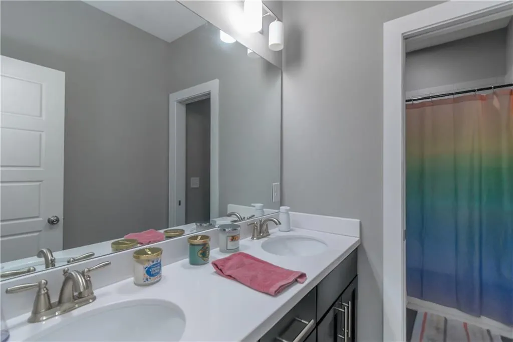 Bathroom featuring double vanity, a sink, and curtained shower