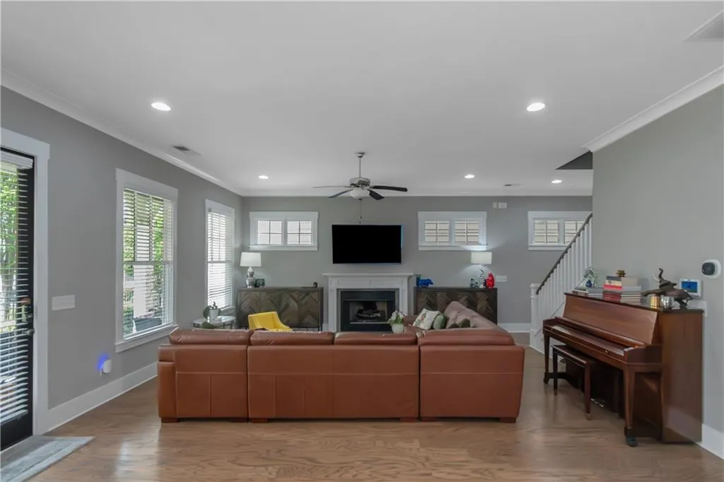 Living room featuring baseboards, ornamental molding, and ceiling fan