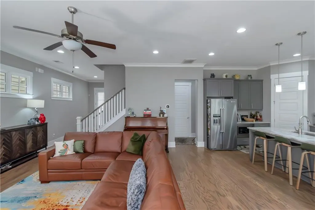 Living room featuring crown molding, ceiling fan, and wood finished floors