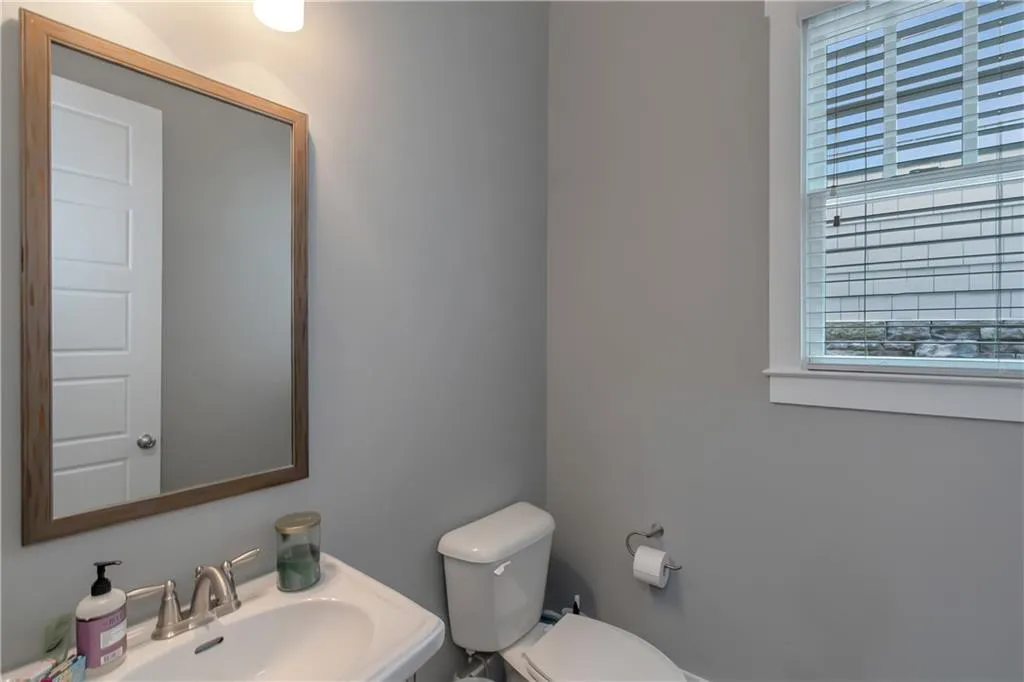 Half bathroom with plenty of natural light, a sink, and toilet