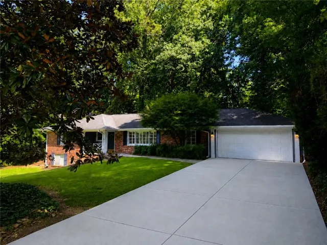 Brick facade exterior with aattached two-car garage, and a concrete driveway