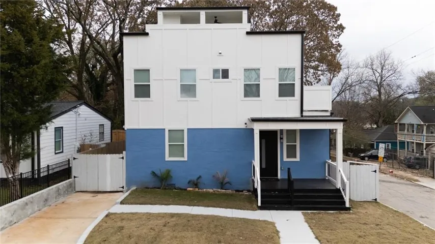 Modern facade featuring white vertical siding and a blue lower level