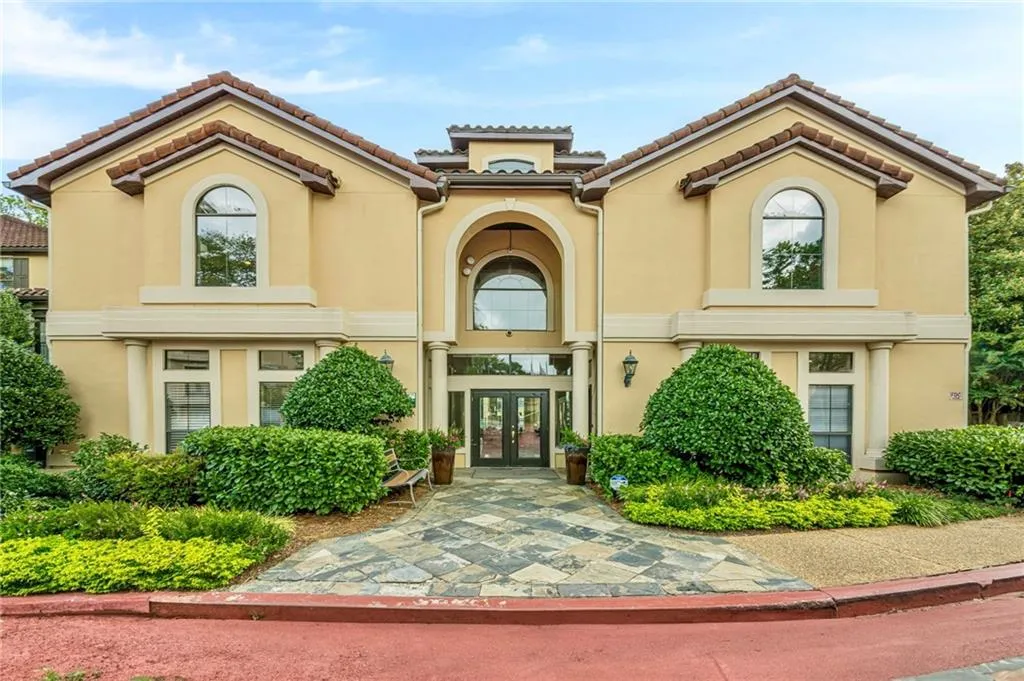 View of front of clubhouse with french doors, stucco siding, and a tiled roof