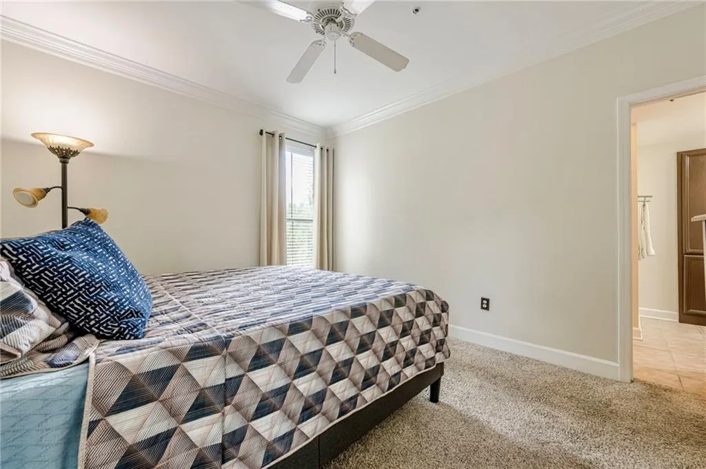 Primary Bedroom featuring ornamental molding, carpet floors, and ceiling fan