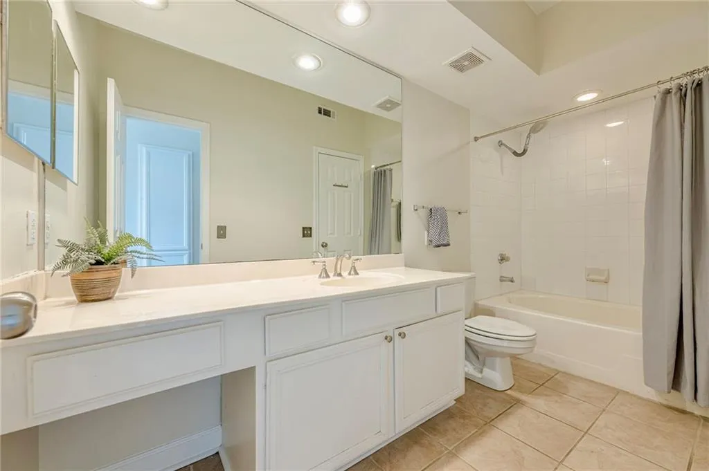 Guest Bathroom with shower / tub combo with curtain, light tile patterned flooring, vanity, and recessed lighting