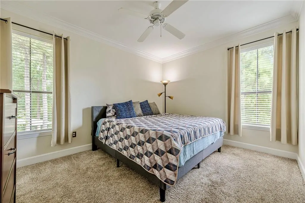 Primary Bedroom featuring crown molding, carpet, and a ceiling fan