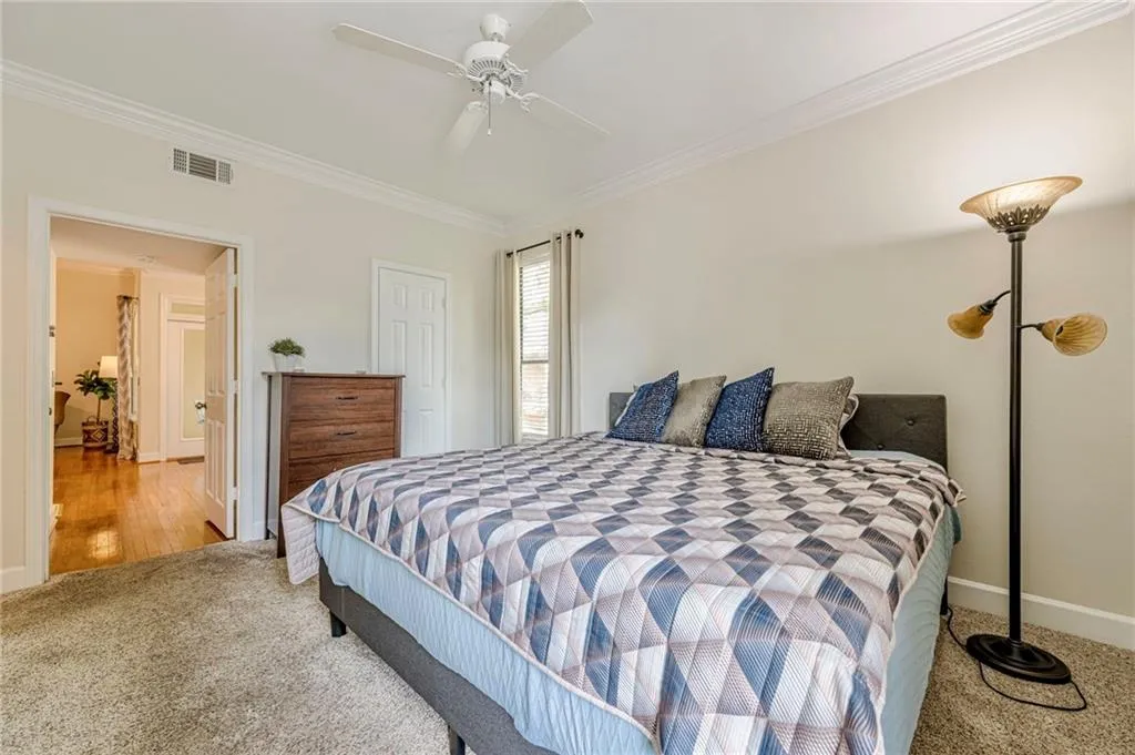 Primary Bedroom with ornamental molding, carpet, and ceiling fan